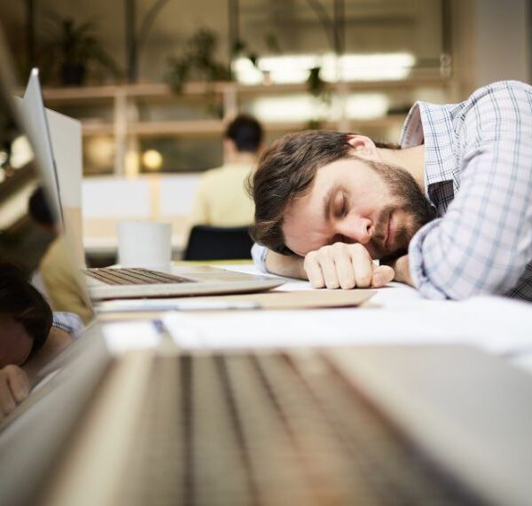 Man sleeping on desk at workplace